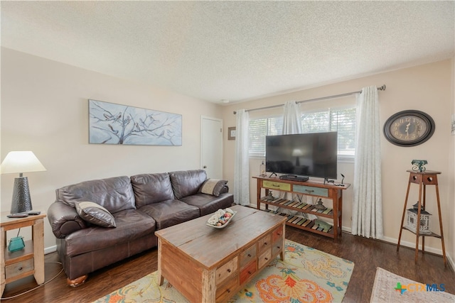 living room featuring dark wood-type flooring and a textured ceiling