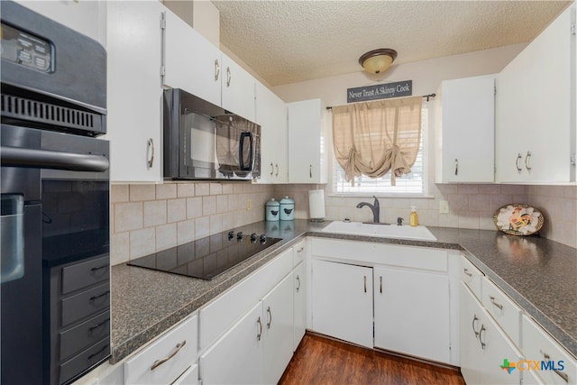 kitchen featuring white cabinetry, dark hardwood / wood-style flooring, black appliances, and sink