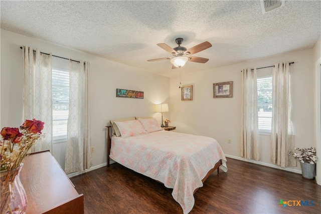 bedroom featuring dark wood-type flooring, ceiling fan, and a textured ceiling