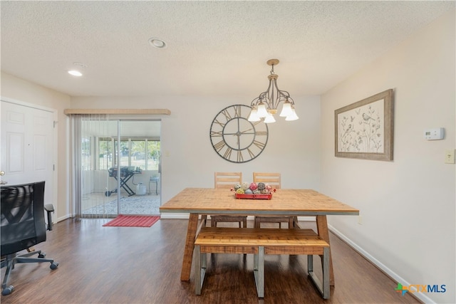 dining space with dark hardwood / wood-style flooring, a chandelier, and a textured ceiling