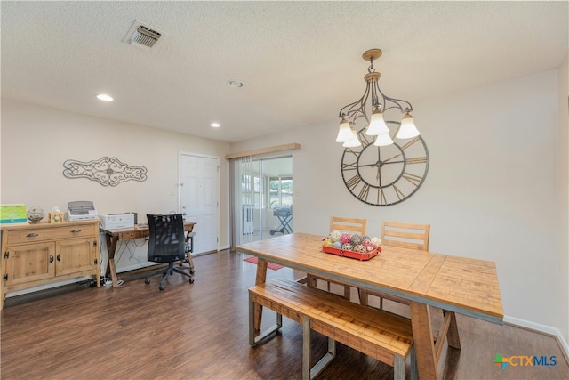 dining area with dark hardwood / wood-style flooring, a chandelier, and a textured ceiling