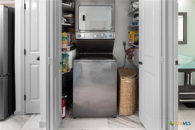 laundry room with laundry area and stacked washer / dryer