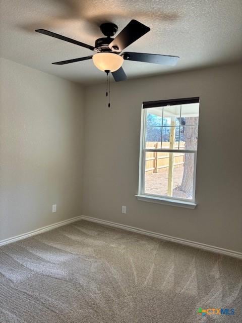 carpeted spare room featuring ceiling fan, a wealth of natural light, and a textured ceiling