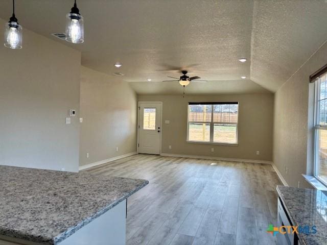 unfurnished living room featuring light wood-type flooring, ceiling fan, a textured ceiling, and lofted ceiling