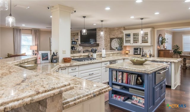 kitchen featuring hanging light fixtures, white cabinets, a spacious island, and light stone countertops