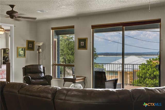 2919 Colleen Dr, Canyon Lake, TX 78133 - living room with visible vents, a water view, a textured ceiling, and ceiling fan
