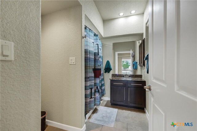 2919 Colleen Dr, Canyon Lake, TX 78133 - bathroom featuring vanity, a shower with shower curtain, baseboards, and a textured wall