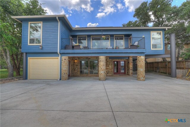 2919 Colleen Dr, Canyon Lake, TX 78133 - view of front of house featuring driveway, fence, french doors, an attached garage, and a balcony
