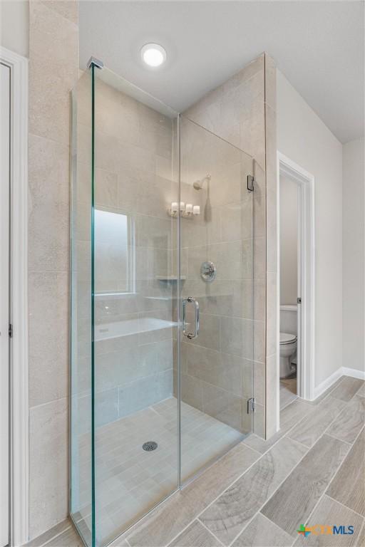 416 Stellar Wind Dr, Georgetown, TX 78628 - bathroom featuring a shower with shower door and toilet
