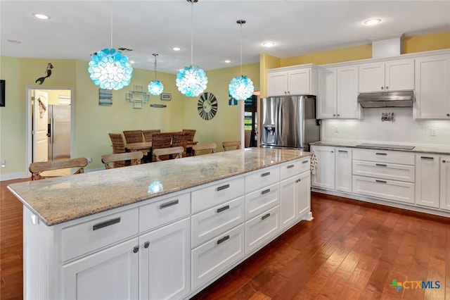 kitchen with under cabinet range hood, dark wood-type flooring, black electric stovetop, and stainless steel fridge with ice dispenser