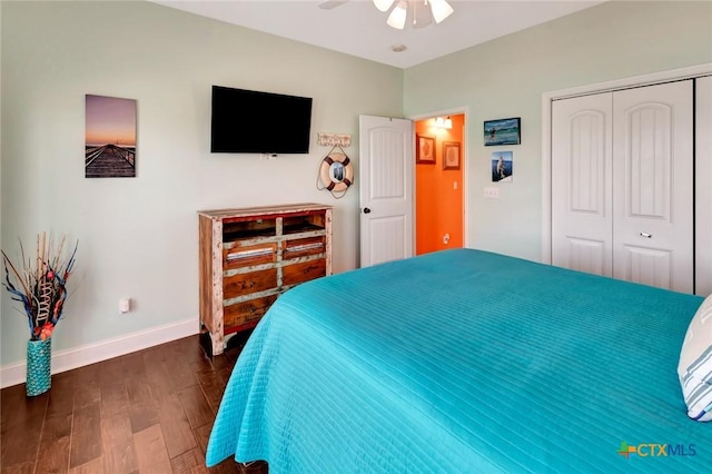 bedroom with a closet, baseboards, dark wood finished floors, and a ceiling fan