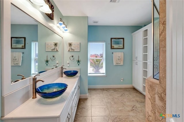 bathroom with visible vents, a healthy amount of sunlight, and a sink