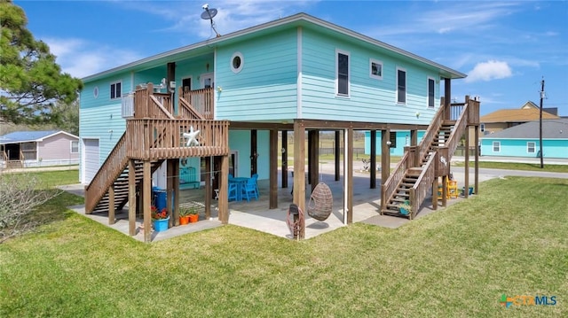 rear view of property featuring stairs, a yard, a deck, a carport, and a patio