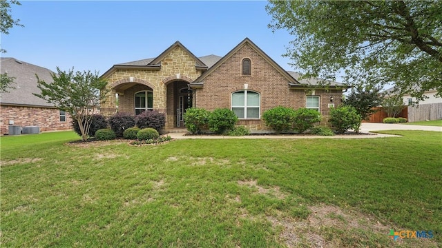 view of front facade with brick siding, central AC unit, and stone siding