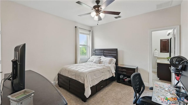 bedroom featuring light colored carpet, baseboards, ensuite bathroom, and ceiling fan