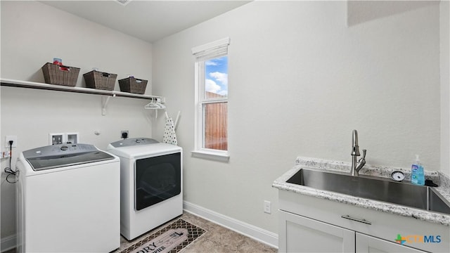 laundry room with separate washer and dryer, cabinet space, baseboards, and light tile patterned floors