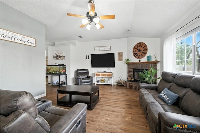 604 Totem Trl, Harker Heights, TX 76548 - living room with wood finished floors, a ceiling fan, a brick fireplace, a textured ceiling, and lofted ceiling