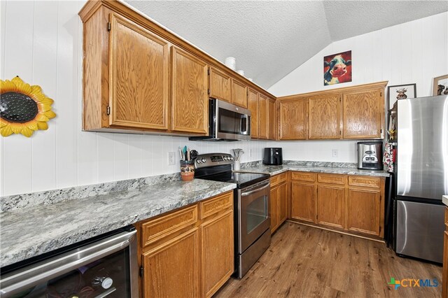 604 Totem Trl, Harker Heights, TX 76548 - kitchen with stainless steel appliances, beverage cooler, dark wood-style flooring, vaulted ceiling, and brown cabinetry