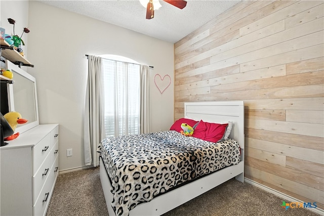 604 Totem Trl, Harker Heights, TX 76548 - bedroom featuring wooden walls, dark carpet, a textured ceiling, and a ceiling fan