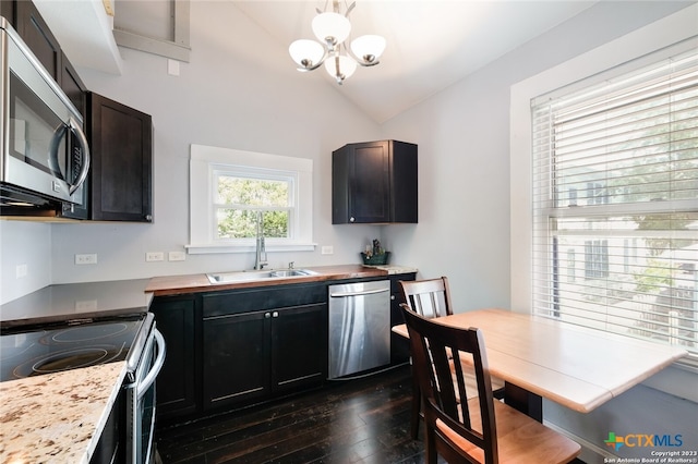 kitchen featuring sink, appliances with stainless steel finishes, a notable chandelier, dark wood-type flooring, and vaulted ceiling