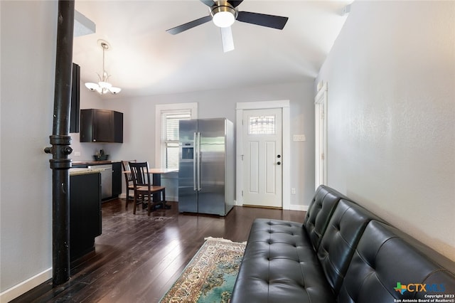 living room featuring vaulted ceiling, ceiling fan with notable chandelier, and dark hardwood / wood-style flooring