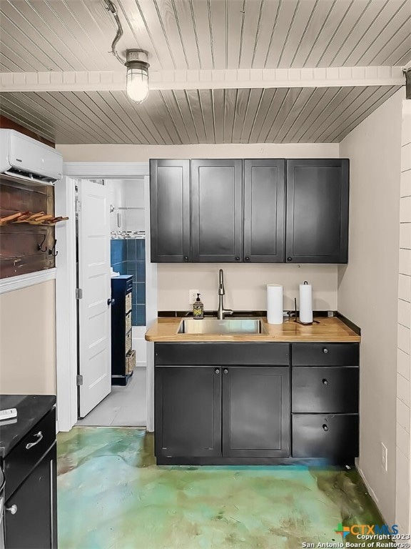 kitchen featuring butcher block counters, sink, and a wall mounted air conditioner