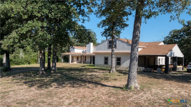 back of house with a yard and a carport