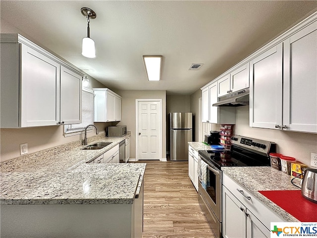 kitchen featuring stainless steel appliances, sink, light wood-type flooring, white cabinets, and pendant lighting