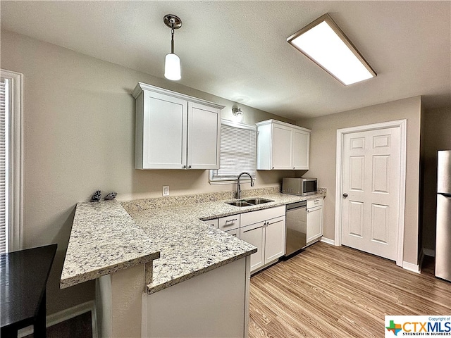 kitchen featuring light hardwood / wood-style floors, white cabinets, kitchen peninsula, sink, and appliances with stainless steel finishes