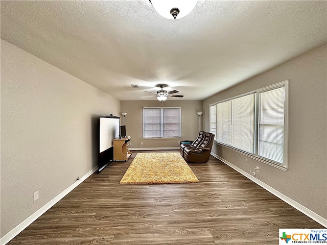 unfurnished room featuring a textured ceiling, dark hardwood / wood-style flooring, and ceiling fan