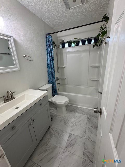bathroom with a textured ceiling, toilet, shower / bath combo with shower curtain, marble finish floor, and vanity