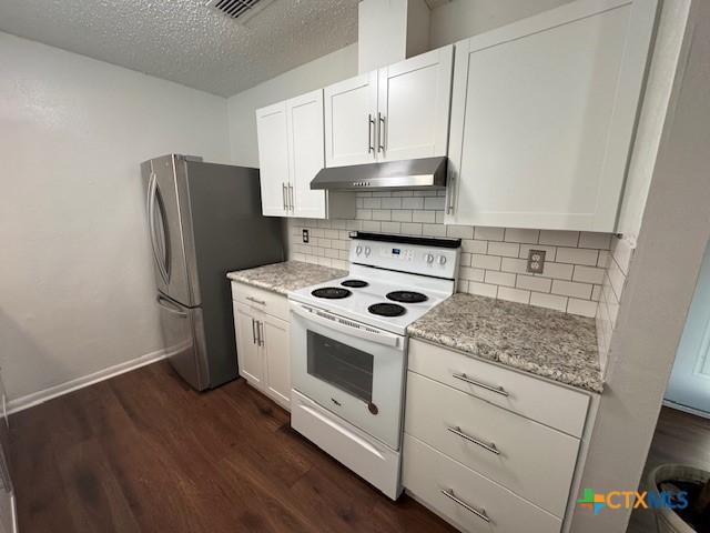 kitchen with under cabinet range hood, white range with electric stovetop, dark wood-type flooring, freestanding refrigerator, and a textured ceiling
