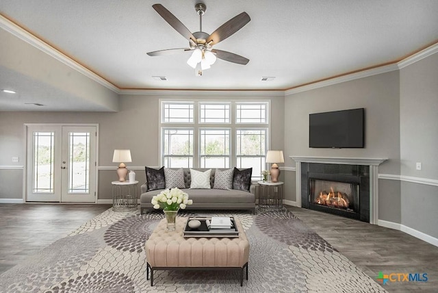 142 Merion Ln, La Vernia, TX 78121 - living room featuring wood finished floors, baseboards, a fireplace, and crown molding