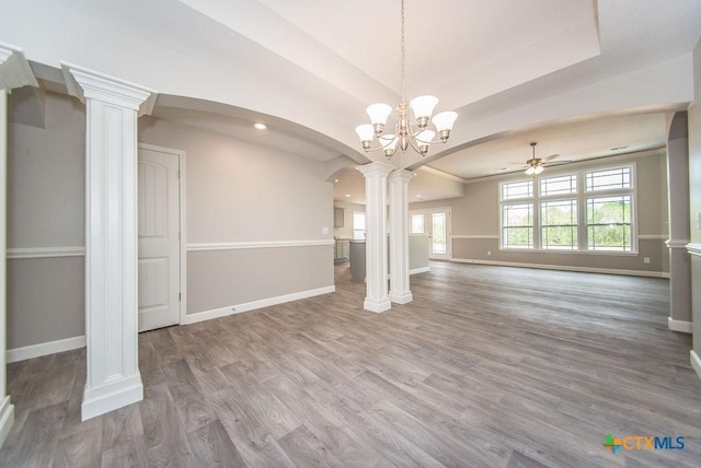 142 Merion Ln, La Vernia, TX 78121 - unfurnished living room with decorative columns, arched walkways, baseboards, wood finished floors, and recessed lighting