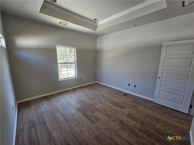 unfurnished room with dark hardwood / wood-style flooring, a tray ceiling, and crown molding