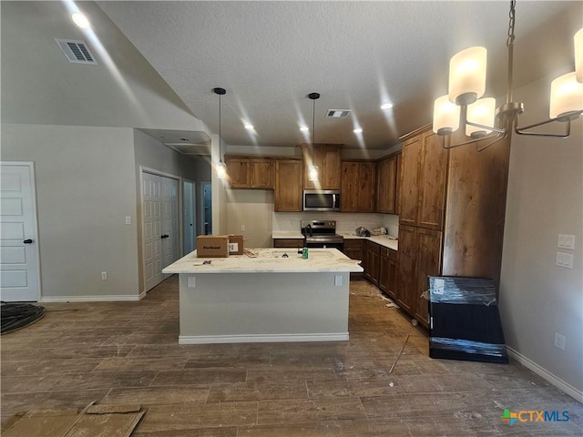 kitchen featuring visible vents, a kitchen island with sink, appliances with stainless steel finishes, and dark wood-type flooring