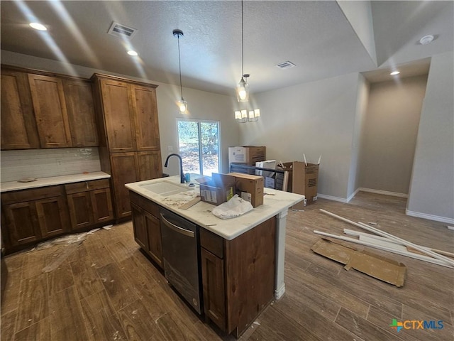 kitchen featuring a sink, visible vents, backsplash, dishwasher, and dark wood finished floors