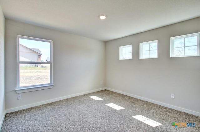 carpeted empty room with baseboards