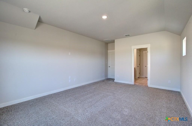 unfurnished bedroom with lofted ceiling, baseboards, visible vents, and light carpet