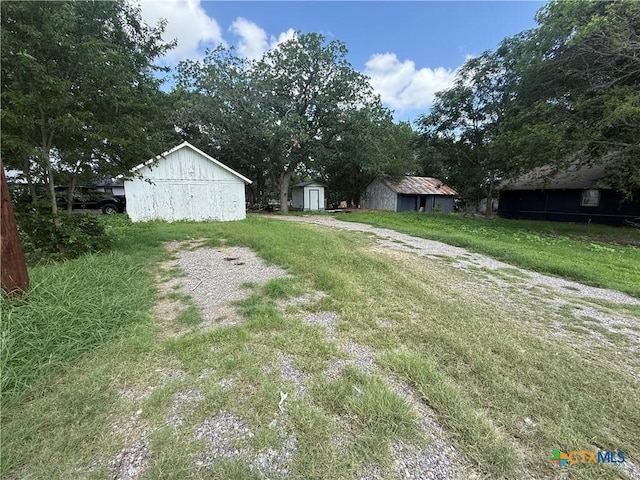 184 3rd St, Maxwell, TX 78656 - view of green lawn featuring a shed