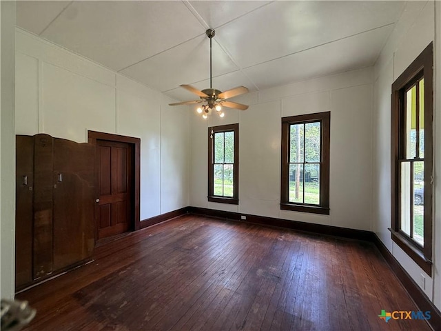 184 3rd St, Maxwell, TX 78656 - spare room with dark wood-type flooring, healthy amount of natural light, ceiling fan, and a decorative wall