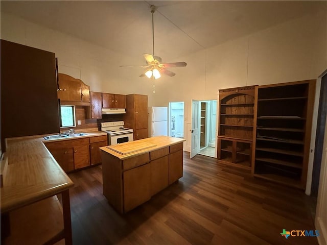 184 3rd St, Maxwell, TX 78656 - kitchen with white appliances, under cabinet range hood, a towering ceiling, dark wood-type flooring, and a kitchen island