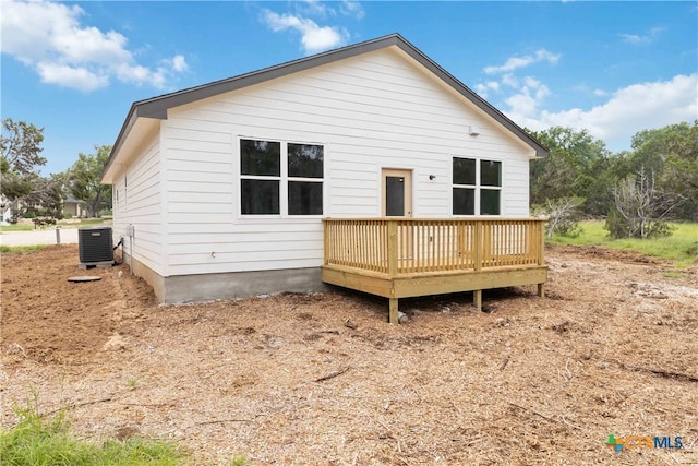 back of house with cooling unit and a wooden deck