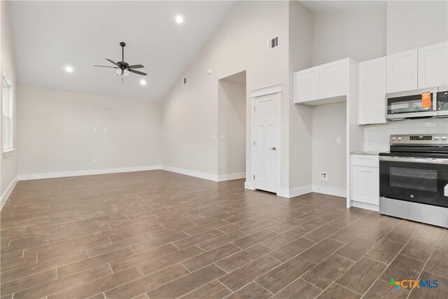 empty room featuring ceiling fan, dark hardwood / wood-style floors, and high vaulted ceiling