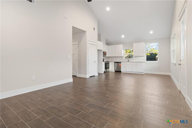 entrance foyer featuring wood-type flooring and high vaulted ceiling