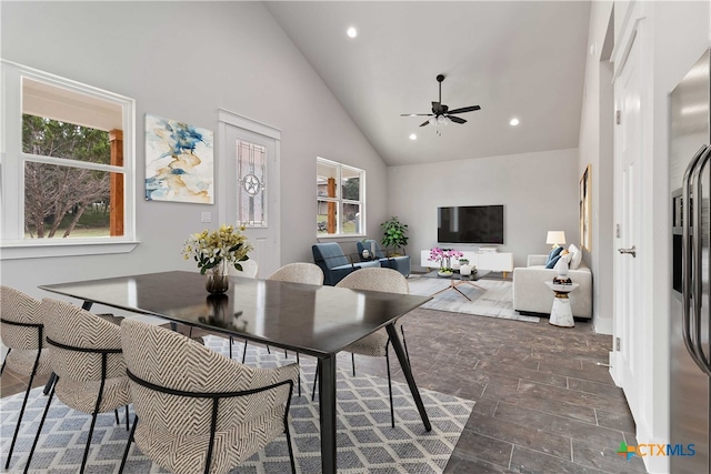 dining space featuring ceiling fan, a healthy amount of sunlight, dark wood-type flooring, and high vaulted ceiling