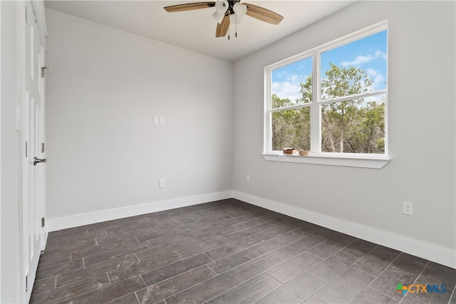 spare room with ceiling fan and dark wood-type flooring