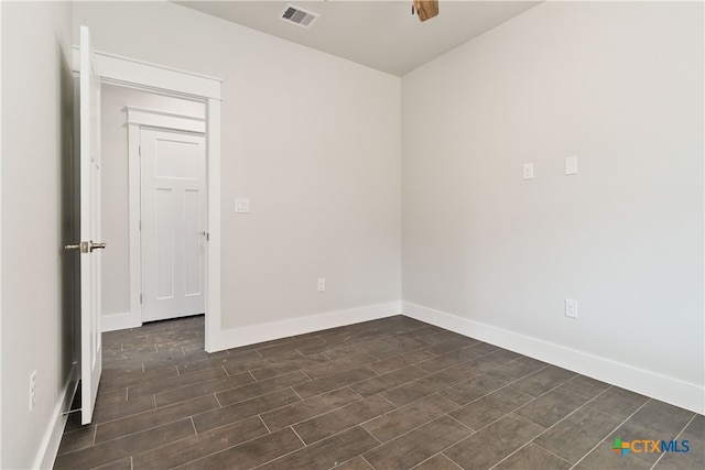 spare room with ceiling fan and dark wood-type flooring