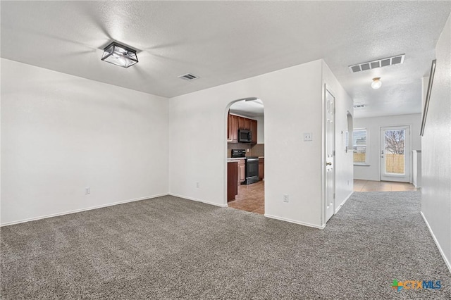 unfurnished living room with a textured ceiling and light carpet