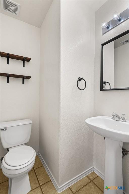 bathroom featuring toilet and tile patterned flooring